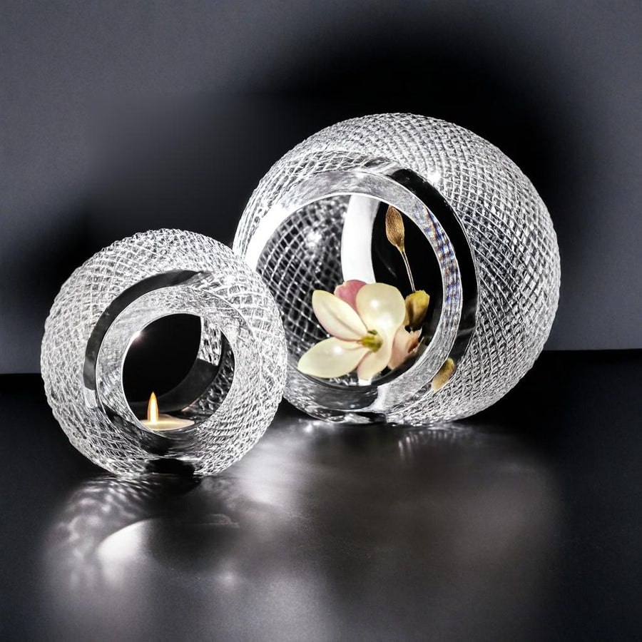 Two crystal candle holders with a flower and candle on a dark background