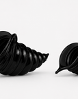 Two glossy black crystal spiral shell-shaped decorative objects displayed side by side on a clean white background.