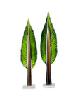 Two decorative leaf sculptures on white stands against a white background