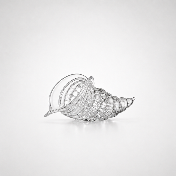 A clear cut crystal seashell-shaped bowl with a ribbed spiral design, photographed on a clean white background.