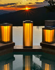 Three solar lanterns by a pool with a sunset over mountains in the background by Les Jardins available at Spacio retail stores in Mumbai & Kolkata. 