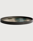 A round decorative tray with a dark charcoal black rim and a light beige interior featuring a pattern of overlapping muted green and brown circles, shown on a light gray background.