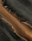 Abstract textured artwork with flowing bands of dark charcoal gray, black, and warm metallic bronze-brown, resembling a close-up of a polished stone or liquid surface.