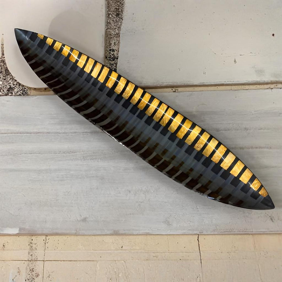 Decorative glass platter with black and gold striped pattern on a light gray surface by Evans Atelier available at Spacio retail stores in Mumbai & Kolkata. 