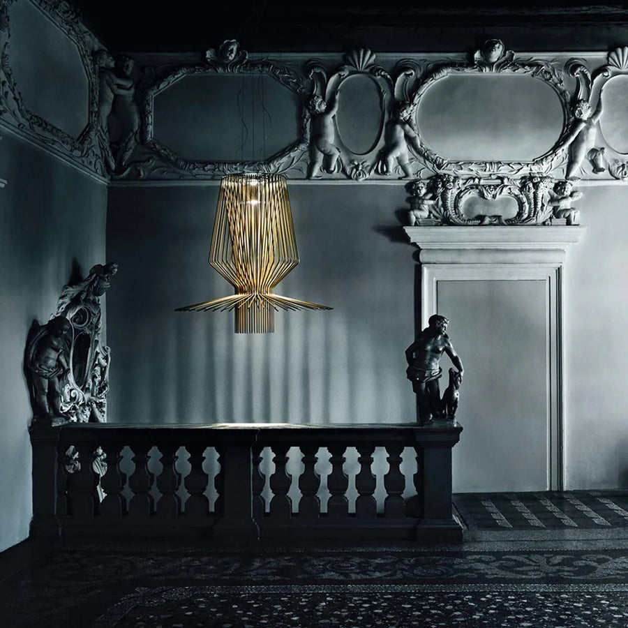 Decorative suspension light hanging in an ornate room with statues and intricate ceiling.