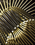 Close-up of gold metal rods arranged in a circular pattern
