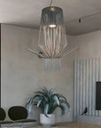 Modern chandelier hanging in a living room with a plant and TV.