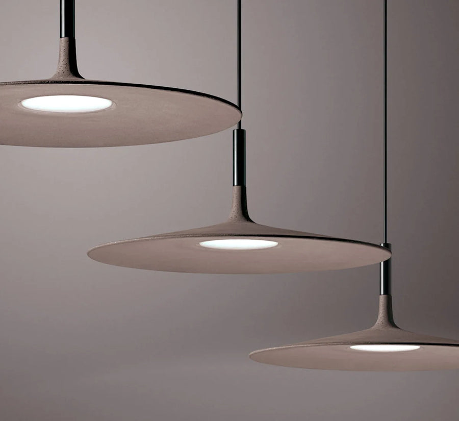Modern pendant light fixture with three round shades on a neutral background