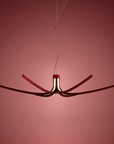 Modern chandelier with red accents on a pink background