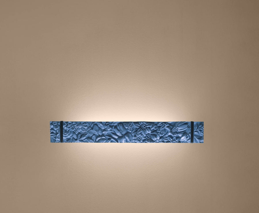Decorative wall sconce with textured design on a beige wall