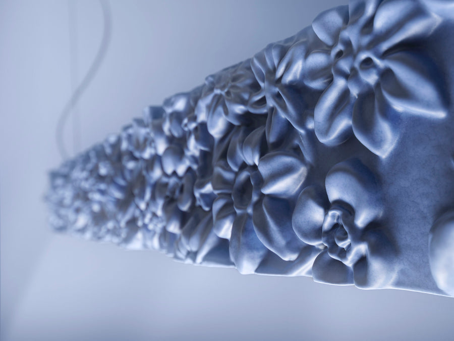 Close-up of a floral-patterned ceramic suspension lamp on a light background