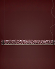 Decorative suspension lamp with intricate carvings on a dark red background