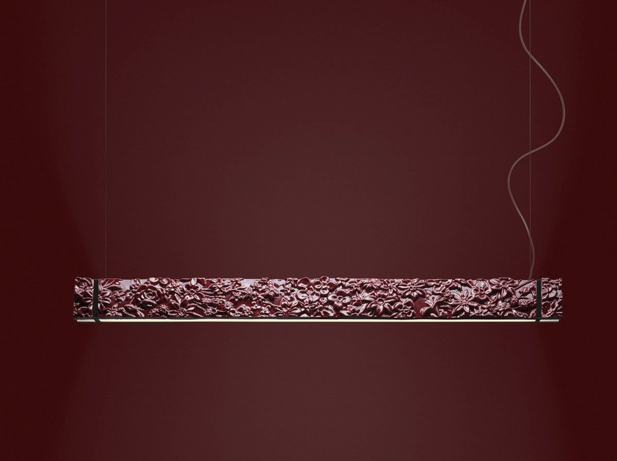 Decorative suspension lamp with intricate carvings on a dark red background