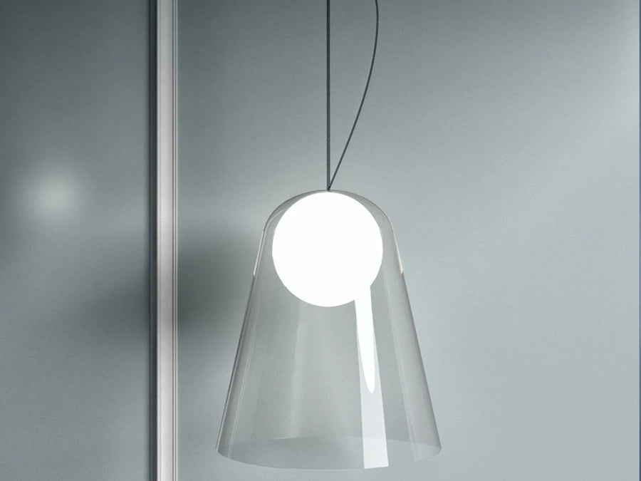 Modern pendant light with a clear glass shade on a gray background
