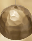 Gold pendant light against a beige background