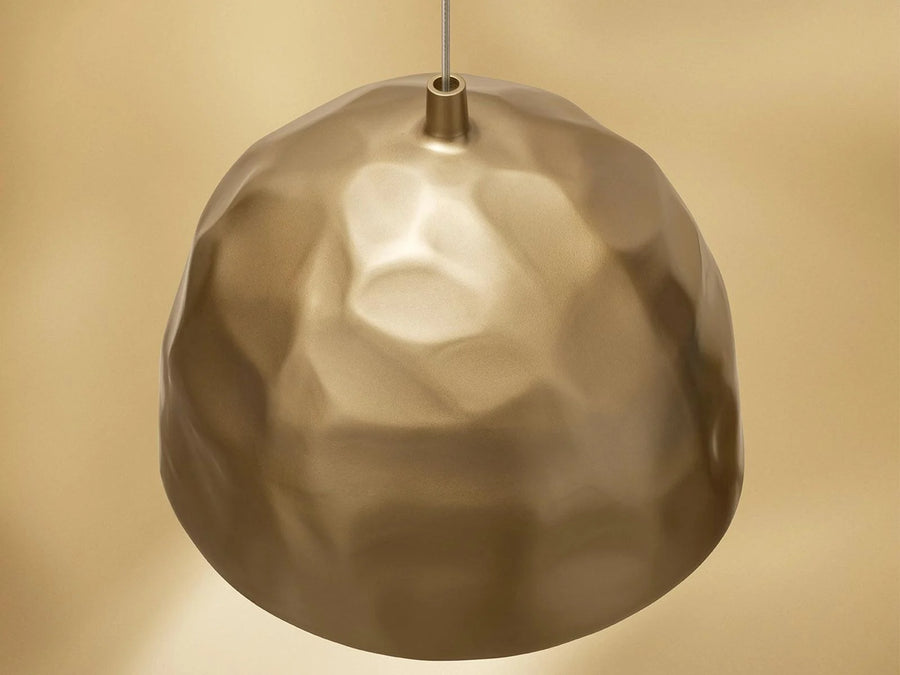 Gold pendant light against a beige background