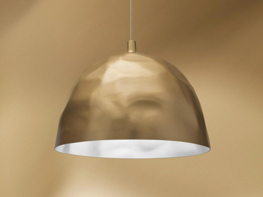 Gold pendant light against a beige background