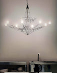 Modern chandelier hanging in a kitchen with neutral walls and minimal decor.