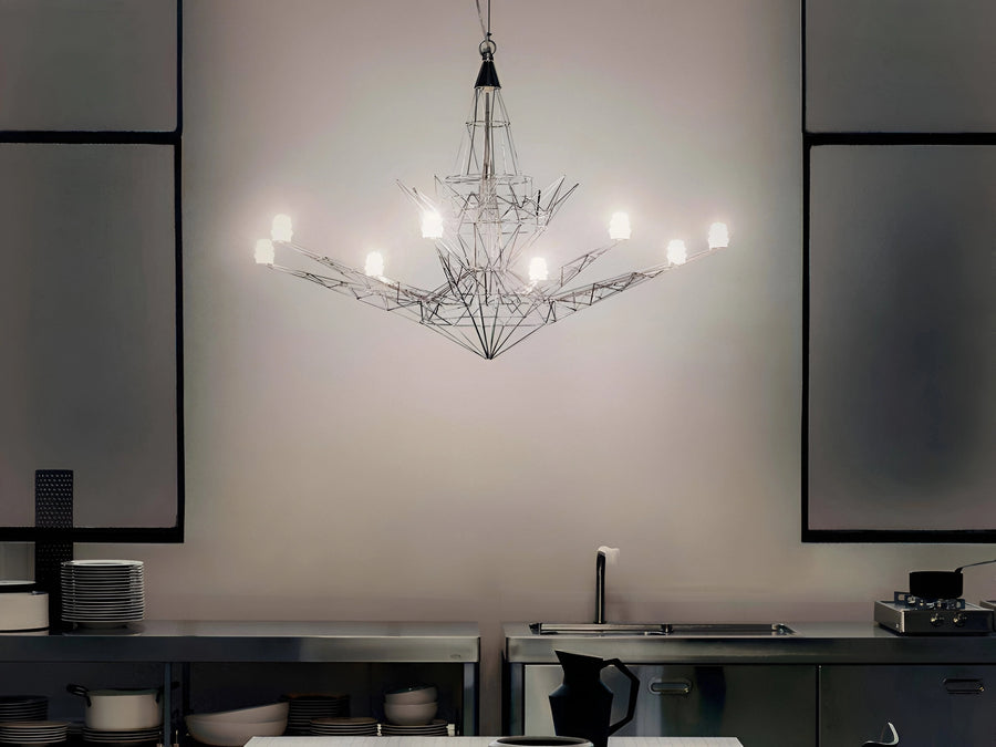Modern chandelier hanging in a kitchen with neutral walls and minimal decor.