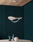 Modern pendant light hanging in a room with dark walls and a wooden ceiling.