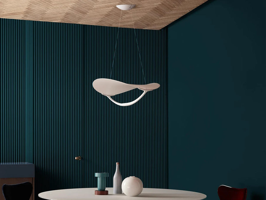 Modern pendant light hanging in a room with dark walls and a wooden ceiling.