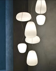 Modern pendant lights hanging against a dark wall with a blue accent.