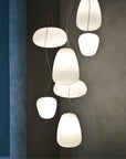Modern pendant lights hanging against a dark wall with a blue accent.
