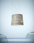 Modern pendant light hanging above a table with chairs on a light blue background