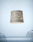 Modern pendant light hanging above a table with chairs on a light blue background