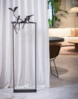A modern outdoor living area with a white sofa and chairs adorned by a Gardeco Bronze Sculpture Love Birds (Limited Edition).