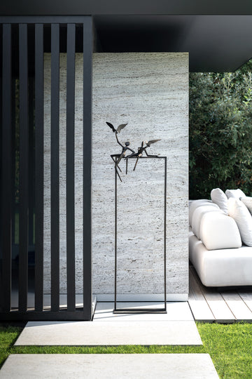 A modern outdoor living area with a white sofa and chairs adorned by a Gardeco Bronze Sculpture Love Birds (Limited Edition).