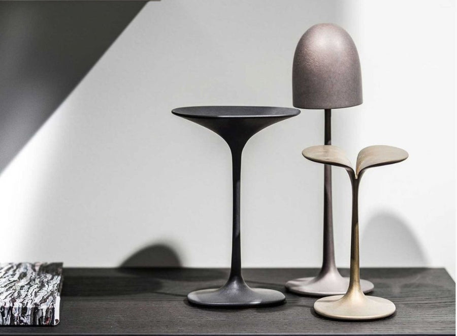 Three Gardeco Bronze Sculpture Mushroom Twin models and a lamp on top of a table.