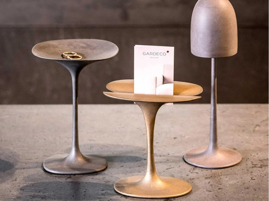 Three Gardeco Bronze Sculpture Mushroom Twin models and a ring stand on a table.