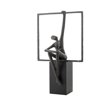Abstract sculpture of a figure sitting on a square base with a rectangular frame above.