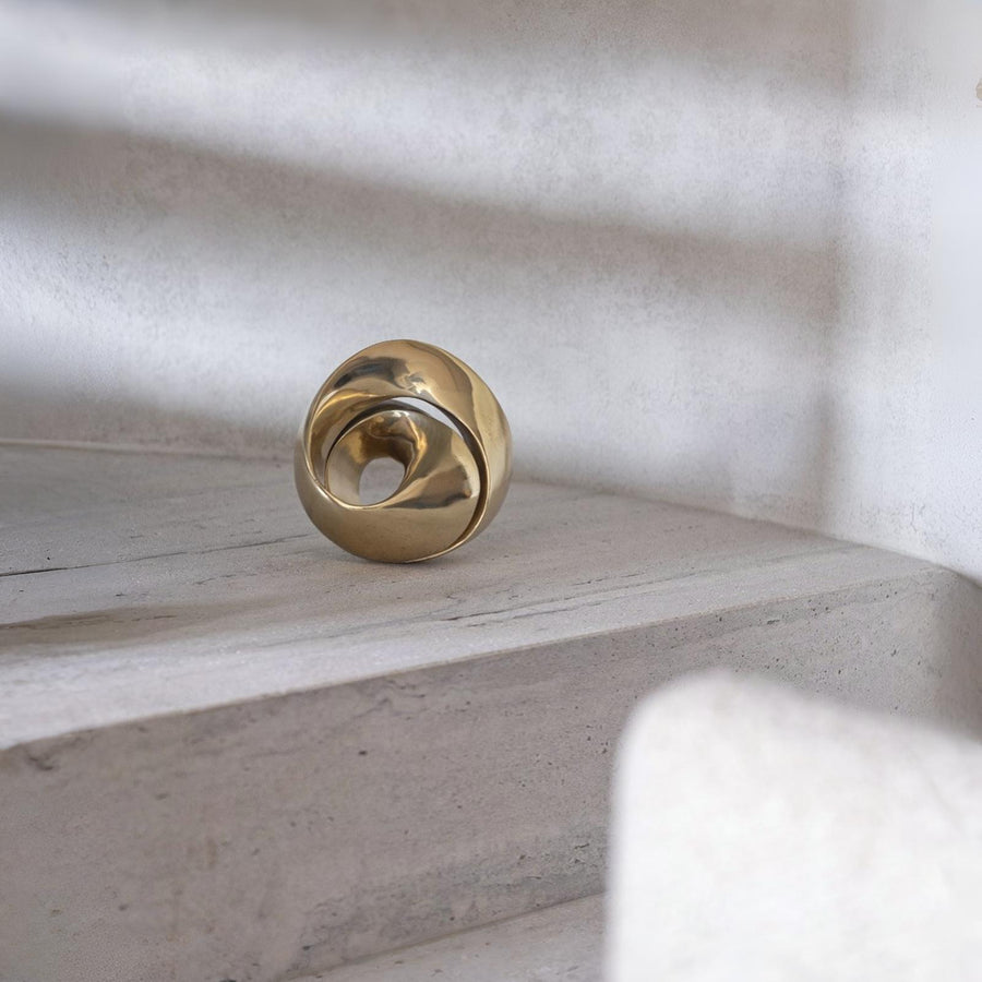 Gold finish bronze object on a textured surface