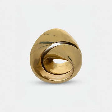Gold finish sculpture with a unique design on a light gray background