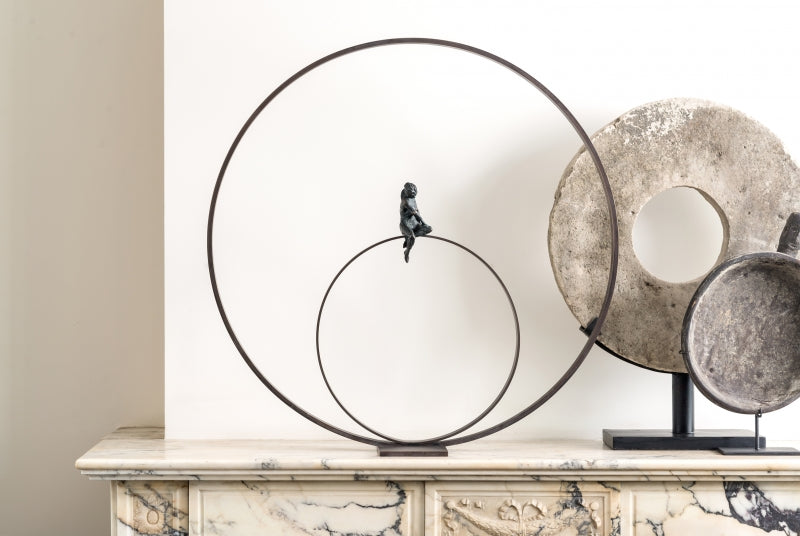 A Gardeco Bronze Sculpture Lost in Thoughts (Limited Edition) of a bird sitting on a circle, created using the lost wax method.