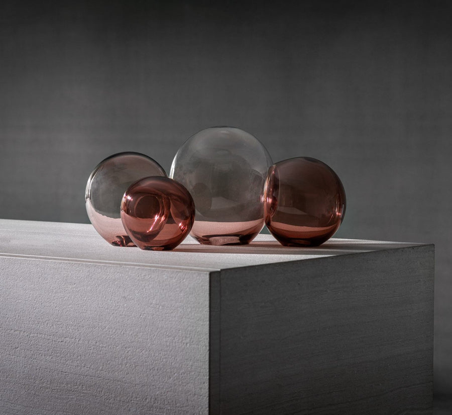 A collection of glass balls arranged on a white surface, showcasing the Gardeco Glass Sculpture Close Encounter Small Purple by Stefan Sch̦ning.