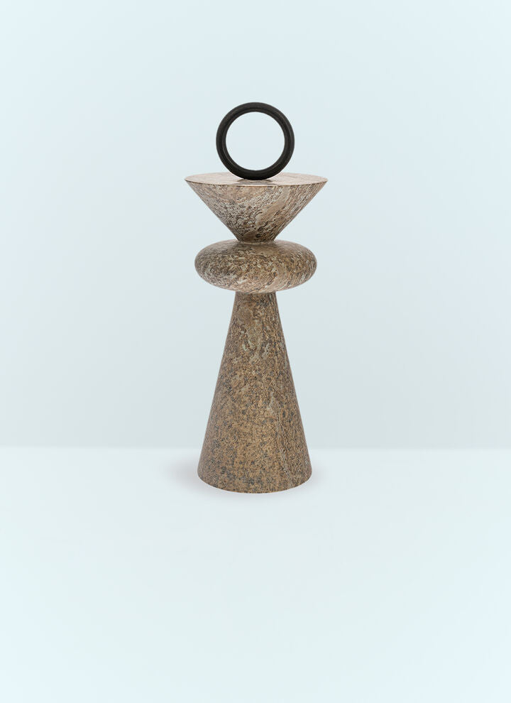 Decorative stone sculpture with a circular top on a light blue background