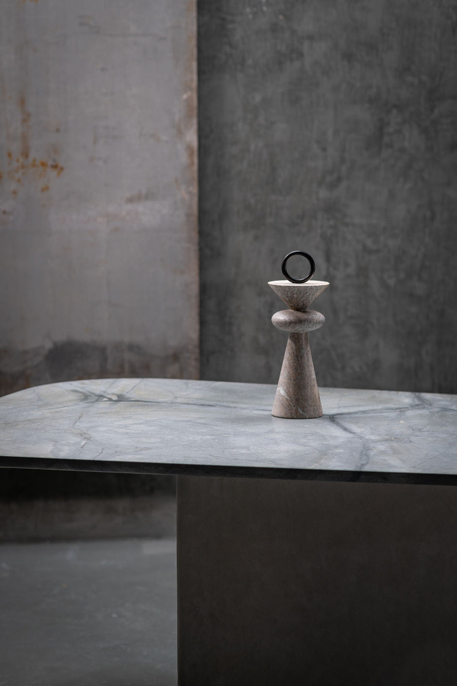 Decorative stone sculpture on a marble surface with a textured wall background