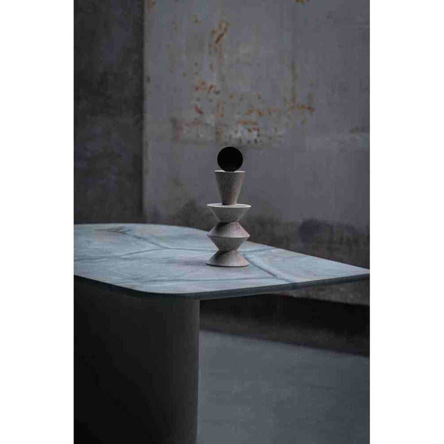 Decorative sculpture on a marble surface with a textured wall background