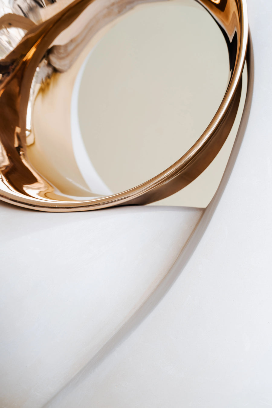 Gold finish bronze decorative item on a white surface