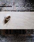 Decorative wall with mosaic pattern and a white bowl with gold interior