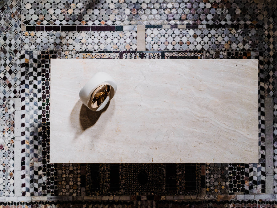Decorative wall with mosaic pattern and a white bowl with gold interior