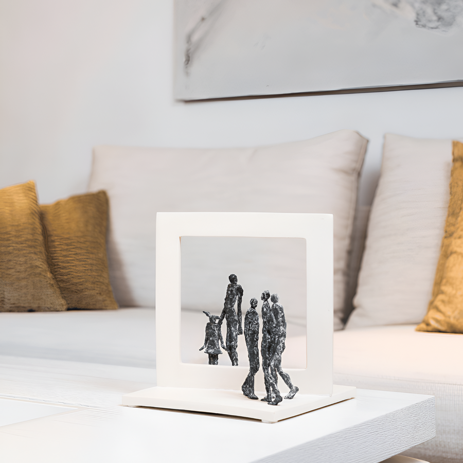 Bronze & stone sculpture of a family on a coffee table in a living room.