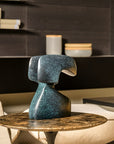 Decorative blue green patina finish bronze sculpture on a table in a modern interior setting