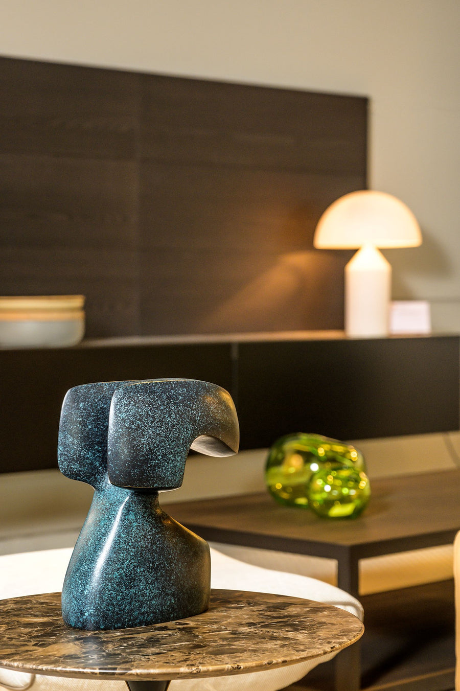 Decorative blue green patina sculpture on a table with a blurred background