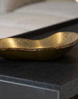 A Brazilian artist's gold bowl, the Gardeco Glass Platter Bowl Ameba Gold with top bronze, elegantly displayed on a table.