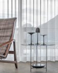 A Gardeco Bronze Sculpture Mushroom Clock lounge chair in front of a window.