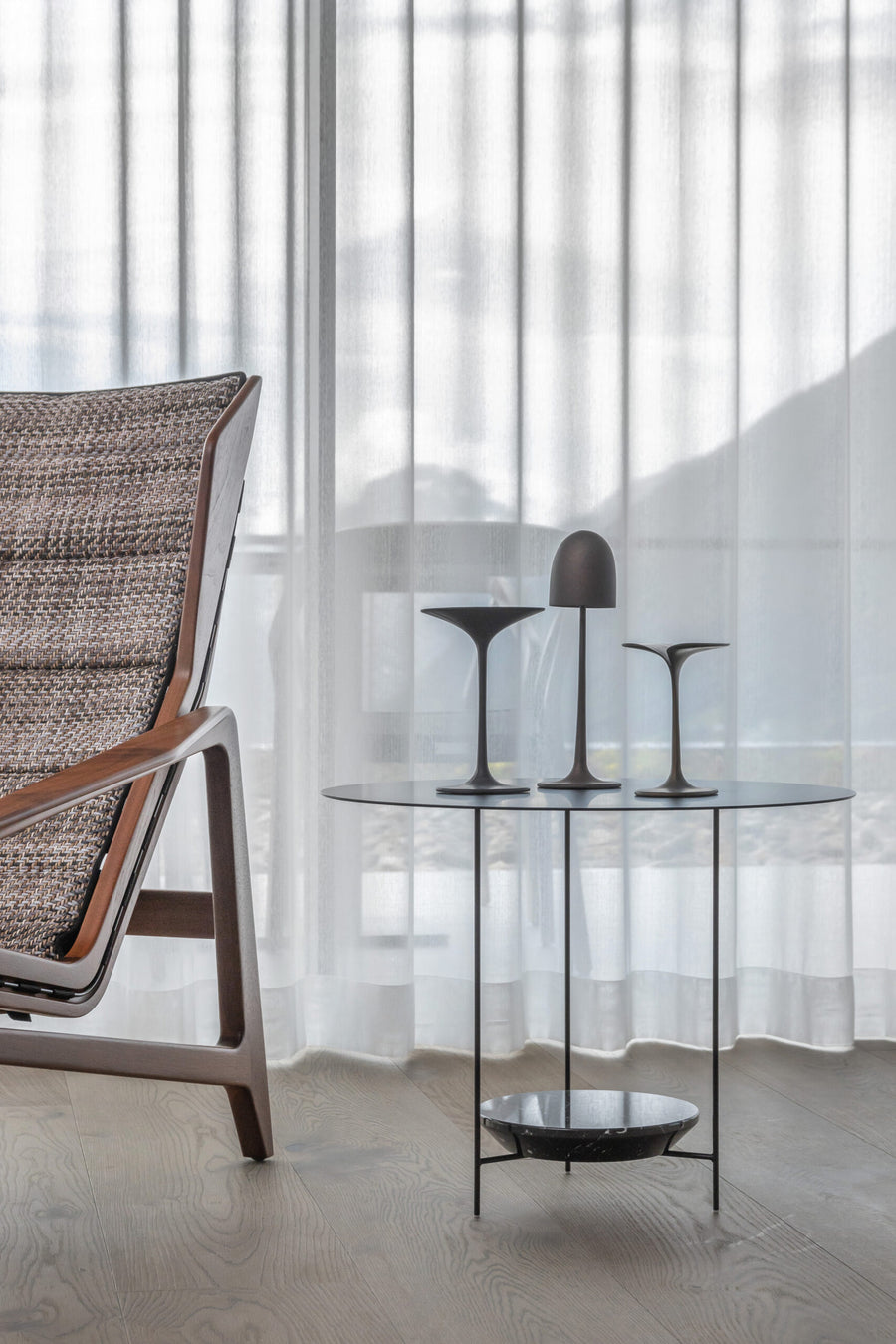 A Gardeco Bronze Sculpture Mushroom Clock lounge chair in front of a window.